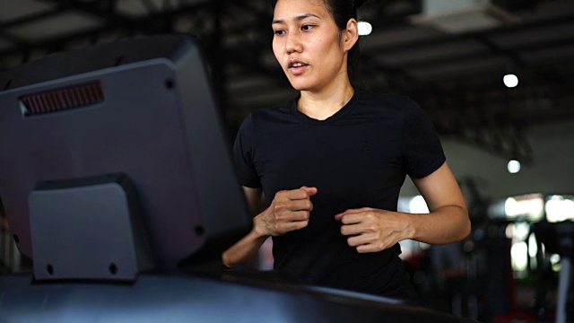 运动女人在跑步机上跑步在健康俱乐部视频素材