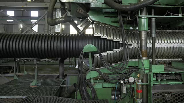 塑料水管制造。生产管子到工厂。用水和空气的压力在机床上制造塑料管的过程。特殊波纹形式。视频素材