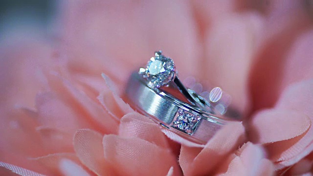微距拍摄的结婚戒指在粉红色的花。婚礼的主题。视频素材