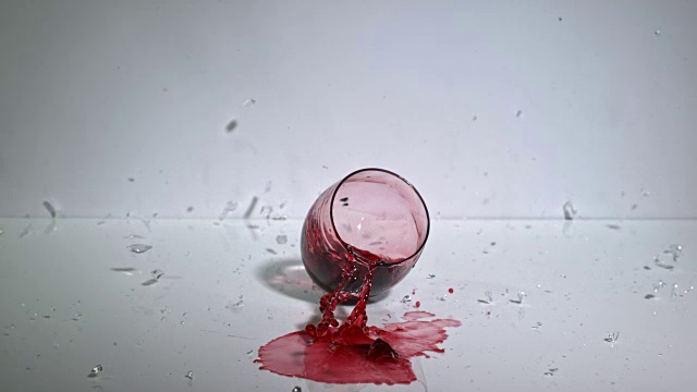 一杯红酒掉在坚硬的表面上摔碎的慢动作镜头。视频素材
