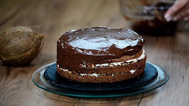 糕点师在蛋糕上涂上巧克力奶油。视频购买