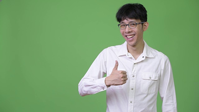 年轻的亚洲商人微笑着竖起大拇指视频下载