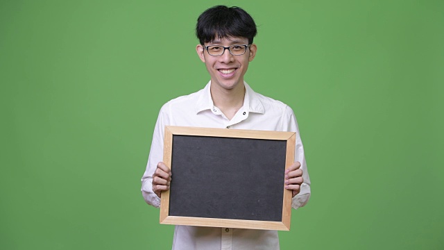 快乐的年轻亚洲商人拿着黑板微笑视频下载