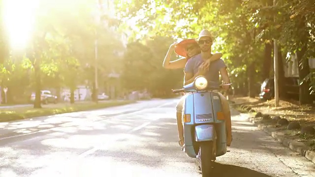一对夫妇骑着摩托车穿过城市街道。视频素材