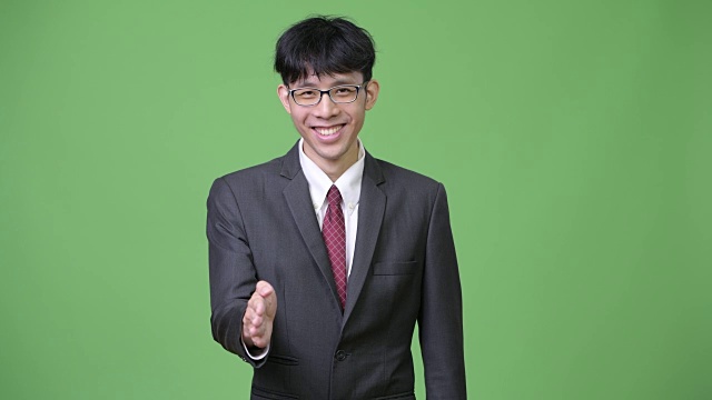 年轻快乐的亚洲商人微笑着握手视频下载