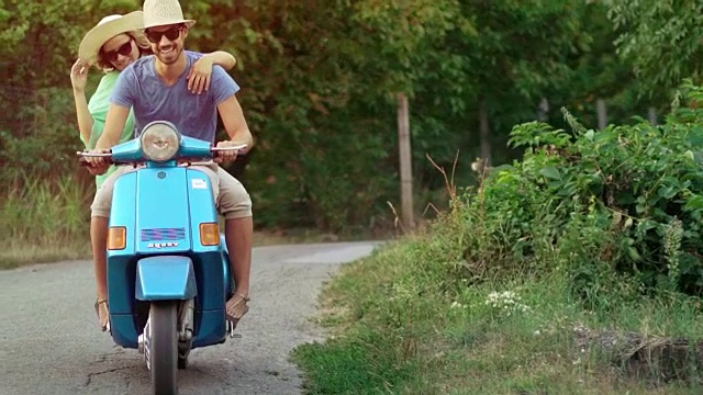 一对夫妇骑着摩托车穿过乡村地区。视频素材