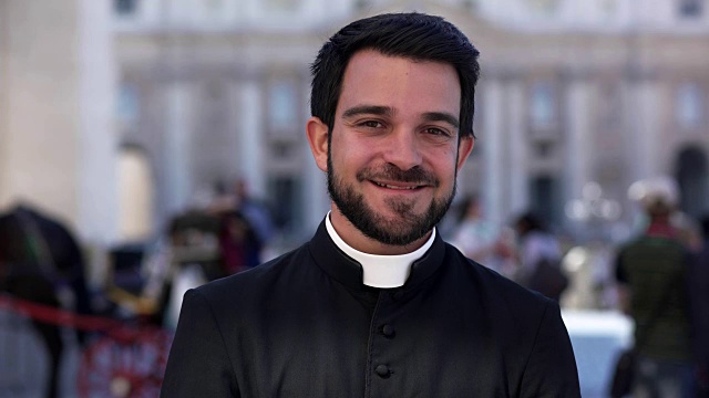 平静善良的年轻牧师对着镜头微笑——圣彼得·巴斯利卡视频下载