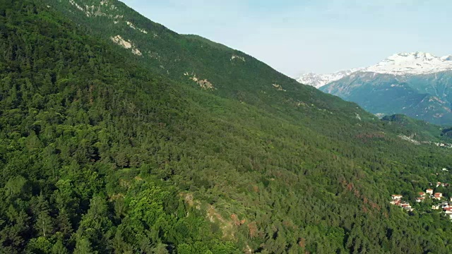 航拍:在春天的阿尔卑斯山脉，飞过山谷和绿色的森林视频下载
