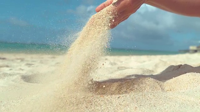 近距离观察:无数的白沙在夏日的微风中飞过沙滩。视频购买