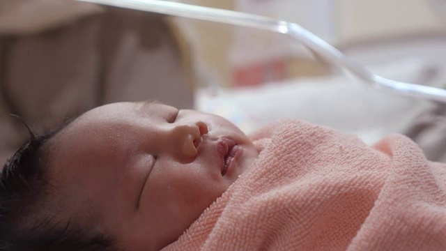 一个可爱的新生婴儿睡在病人康复室里视频下载