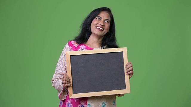 成熟快乐美丽的印度女人一边思考一边展示黑板视频下载