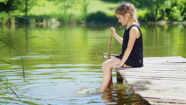 女孩的腿在池塘里溅水视频下载