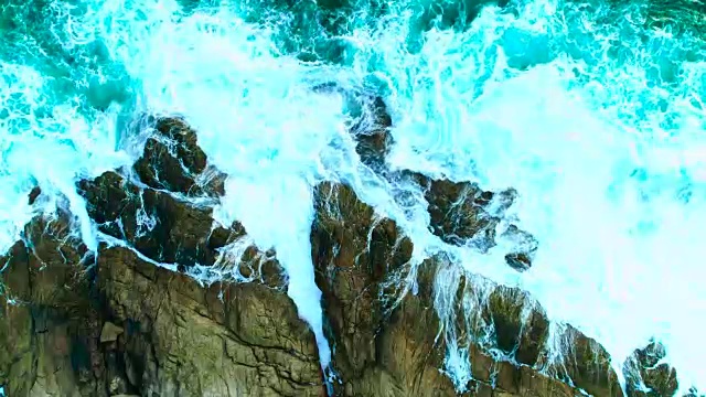 天线:岩石嶙峋的海岸线上美丽的海浪和白色的泡沫。视频素材