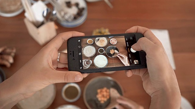 用手机摄像头拍下餐厅里的食物，用于社交网络视频素材