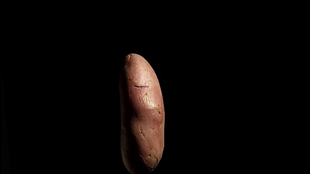 红土豆在黑色背景上旋转视频素材