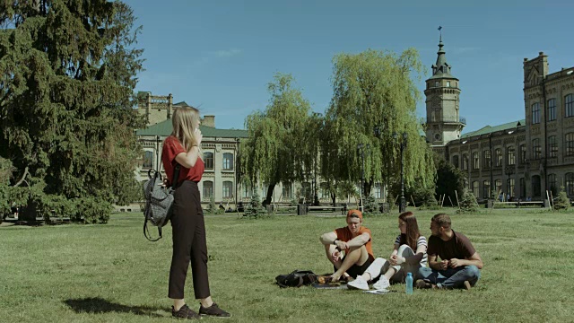 一个女大学生在校园草坪上用智能手机聊天视频素材
