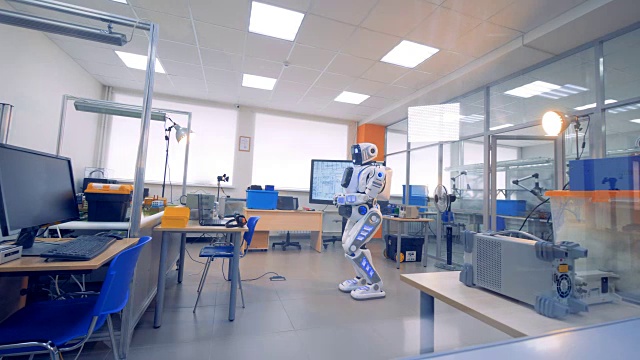 一个半机械人一动不动地站在工程实验室的中央视频下载