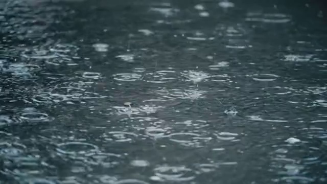 4K慢镜头拍摄雨落在人行道上。视频下载