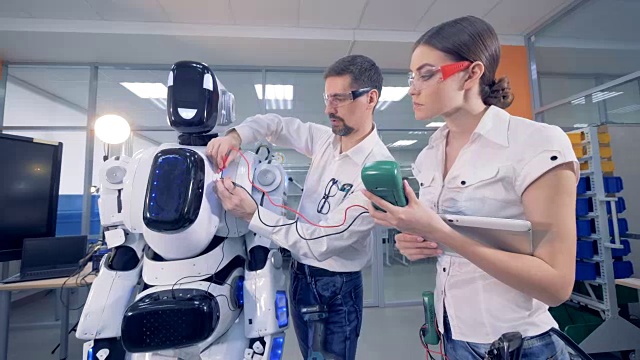 人们在机器人上用安培表工作。视频素材