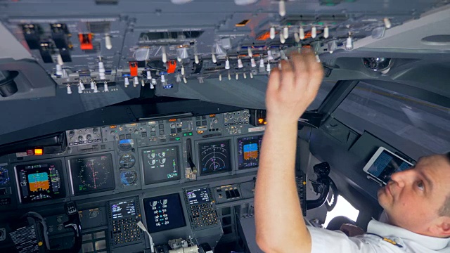 飞行员在飞行前正在切换驾驶舱上方的按钮视频素材