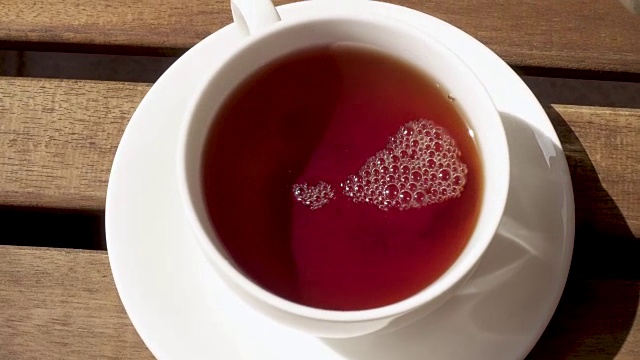 早上，茶杯放在木桌上的茶托上视频下载