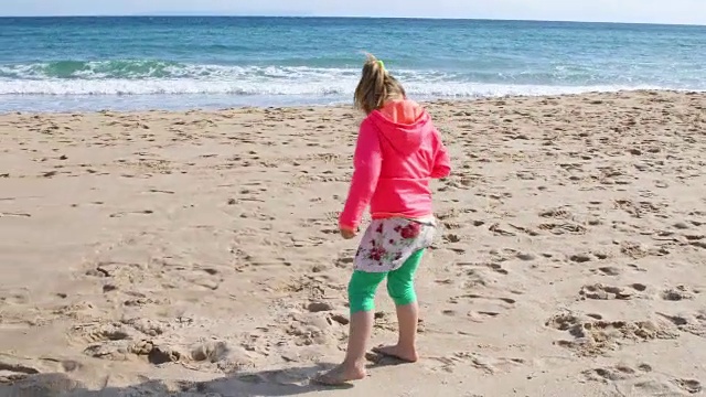 在海滩上寻找贝壳的女孩视频素材