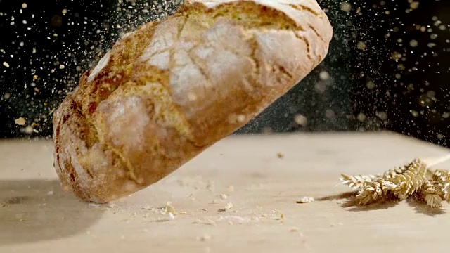 粗糙的硬壳圆面包落在桌子上视频素材