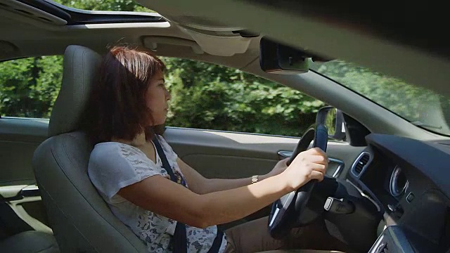 年轻女性开车，侧射视频素材