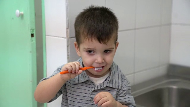 可爱的小男孩在幼儿园的浴室里刷牙视频素材