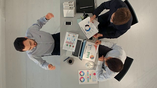 创意团队展示图表与笔记本电脑和平板电脑坐在桌子上办公。顶级竞争视频下载