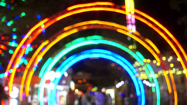 晚上在游乐园入口处，以五颜六色的灯光为背景的现代景点。视频下载