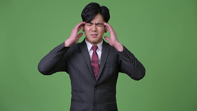 压力年轻英俊的亚洲商人头痛视频下载