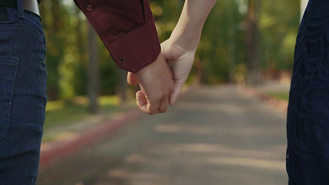 年轻夫妇走在一起手牵手从近距离的后方视角视频素材