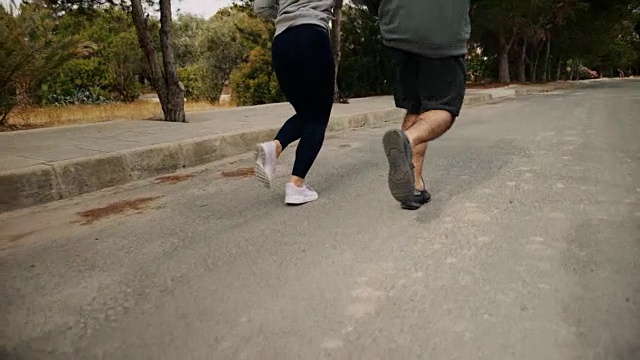一对情侣一起在郊区街道慢跑的特写视频素材