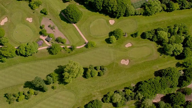 鸟瞰图在阳光美丽的高尔夫球场。4K视频下载