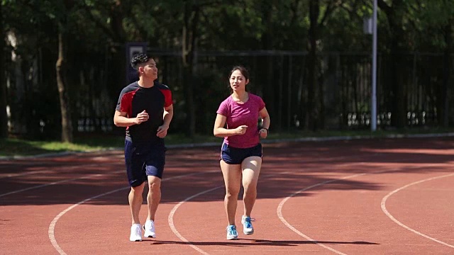 年轻的亚洲夫妇在体育场慢跑视频素材