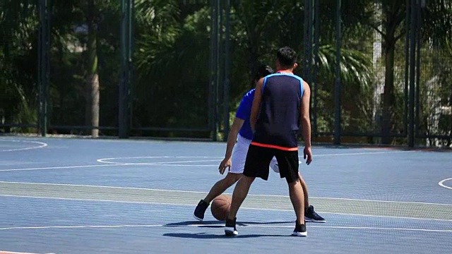 年轻的亚洲篮球运动员在户外球场视频素材