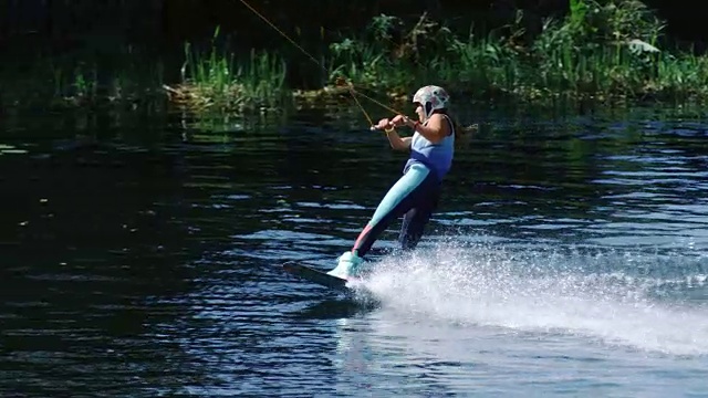 运动女子在水上滑行。在湖上学习滑水的女孩视频素材