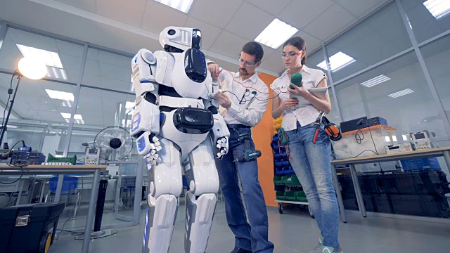 两名专业人员正在测量一个半机械人的工作设置视频素材
