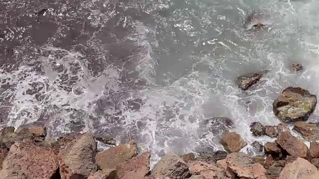 海浪撞击岩石，海浪撞击伊比沙海滩岩石的航拍图像视频素材