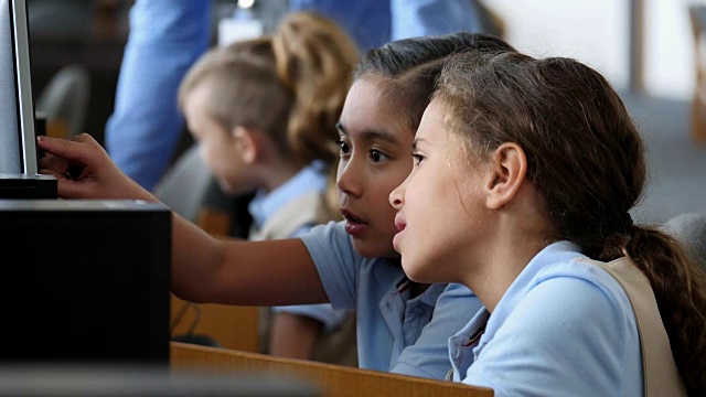 专注于STEM的小学女生在计算机实验室学习计算机视频下载