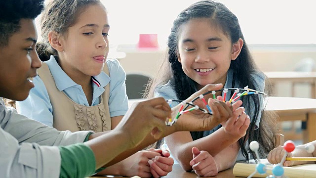 青少年科学导师向女小学生讲解DNA螺旋结构视频素材