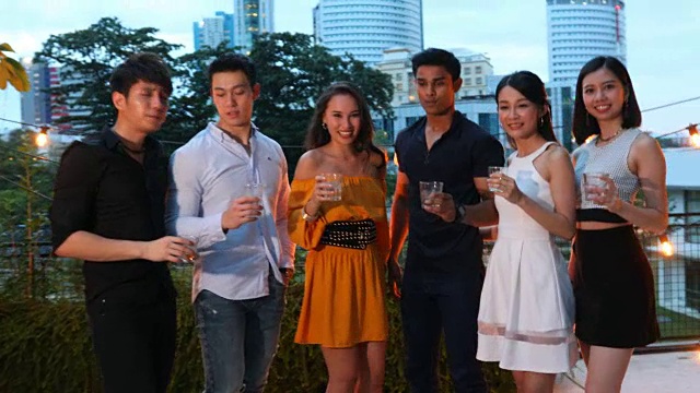 一群亚洲年轻人在屋顶上聚会和敬酒的视频视频素材