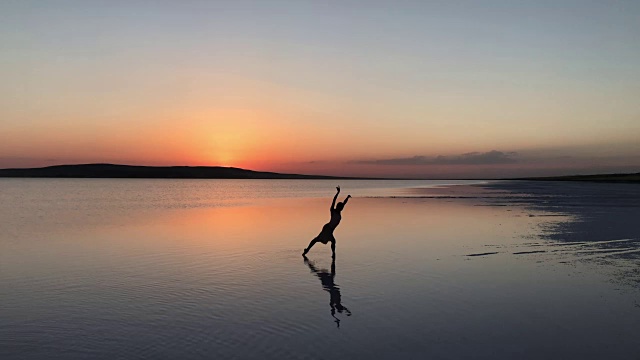 傍晚，年轻的芭蕾舞演员在湖面上跳舞。视频素材