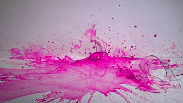 一个实验室烧杯里的紫色液体在坚硬的表面上粉碎的慢镜头。视频素材