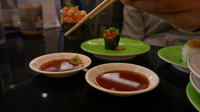 在日本餐厅酒吧里，用寿司拉近筷子的距离视频素材