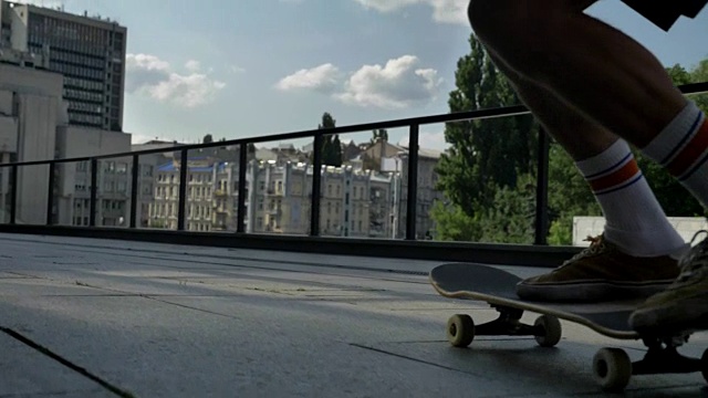 年轻人滑板在夏天白天做滑板把戏的腿，运动概念，城市概念，后视图视频素材