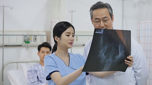 医生和护士在看x光扫描时谈话视频素材