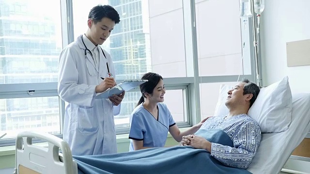 医生和护士在病床上和病人谈话视频素材