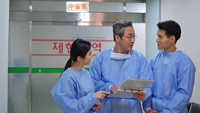 医生和护士在手术室旁边交谈视频素材